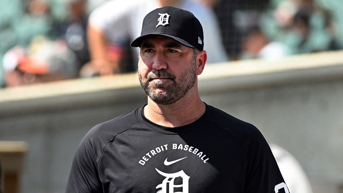 Justin Verlander watches from the dugout during a baseball game.