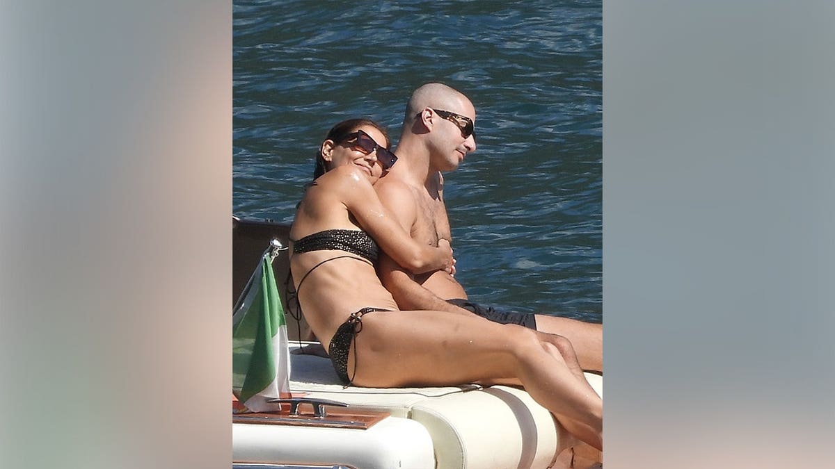 Katie Holmes and her boyfriend cuddling on a boat in Italy.