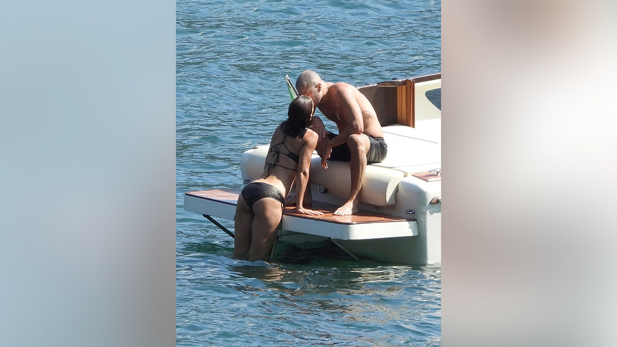 Katie Holmes and Jason Yarmosky shared a kiss as she climbed back onto the boat after a swim.