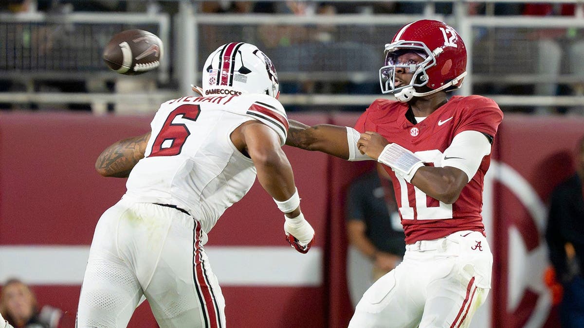 Alabama quarterback Keelon Russell (12) makes a sidearm throw around South Carolina edge rusher Dylan Stewart (6).