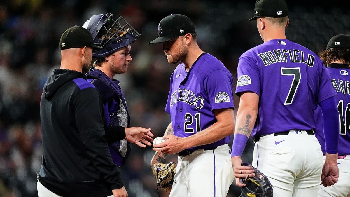 Kyle Freeland hands the ball to manager Warren Schaeffer as he is pulled from the mound during a baseball game.