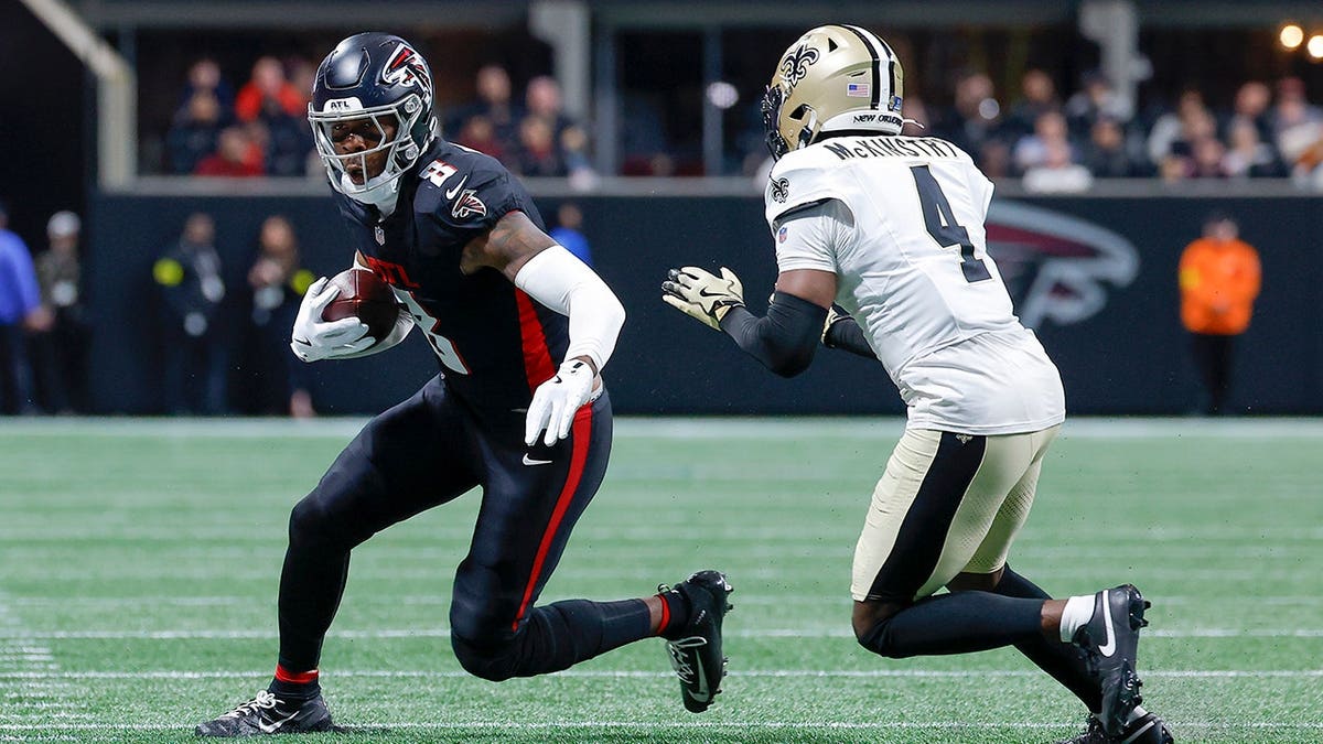Kyle Pitts Sr. turns upfield while Kool-Aid McKinstry pursues during an NFL game.