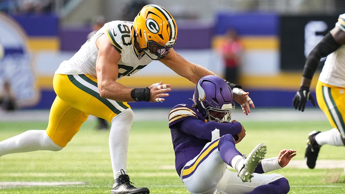 Kyler Murray of the Minnesota Vikings is tackled by Green Bay Packers defenders during a football game.