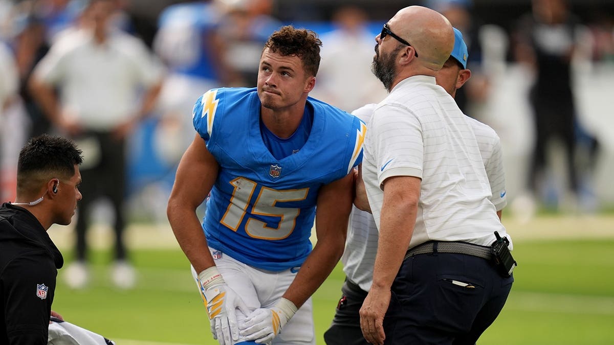 Ladd McConkey slowly gets up after an injury during an NFL game.