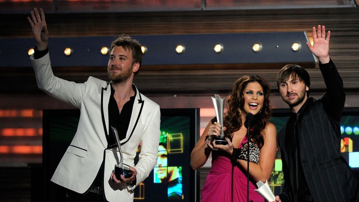 Lady Antebellum members Charles Kelley, Hillary Scott, and Dave Haywood accept the Song of the Year award onstage.