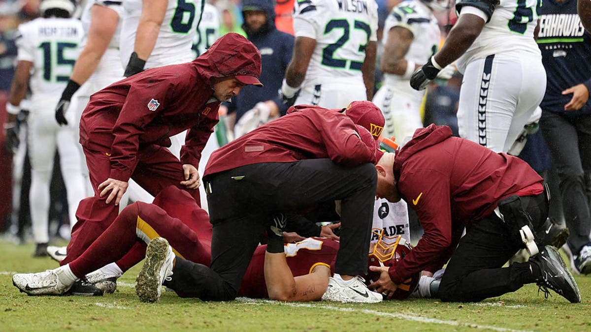 Leo Chenal #54 goes down with an injury during a Washington Commanders game against the Seattle Seahawks.