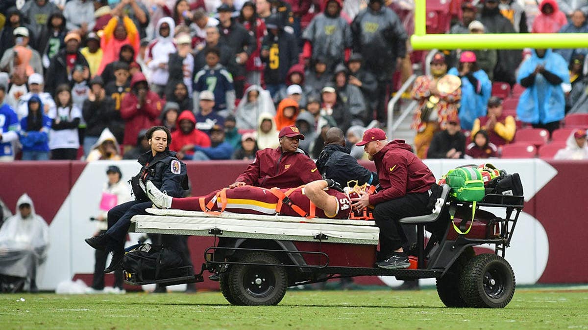 Washington linebacker Leo Chenal is carted off the field at Northwest Stadium.