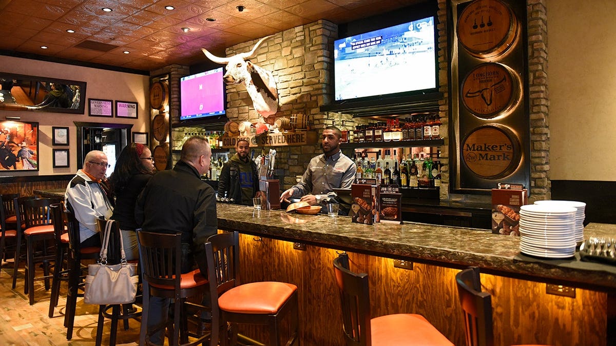 Bar area inside LongHorn Steakhouse with seating and fixtures visible.