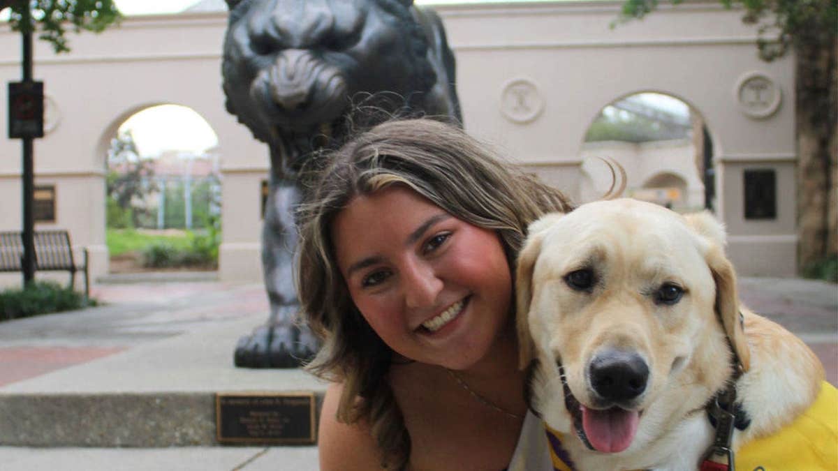 A Canine Companions dog is seen with its raiser on the LSU campus.