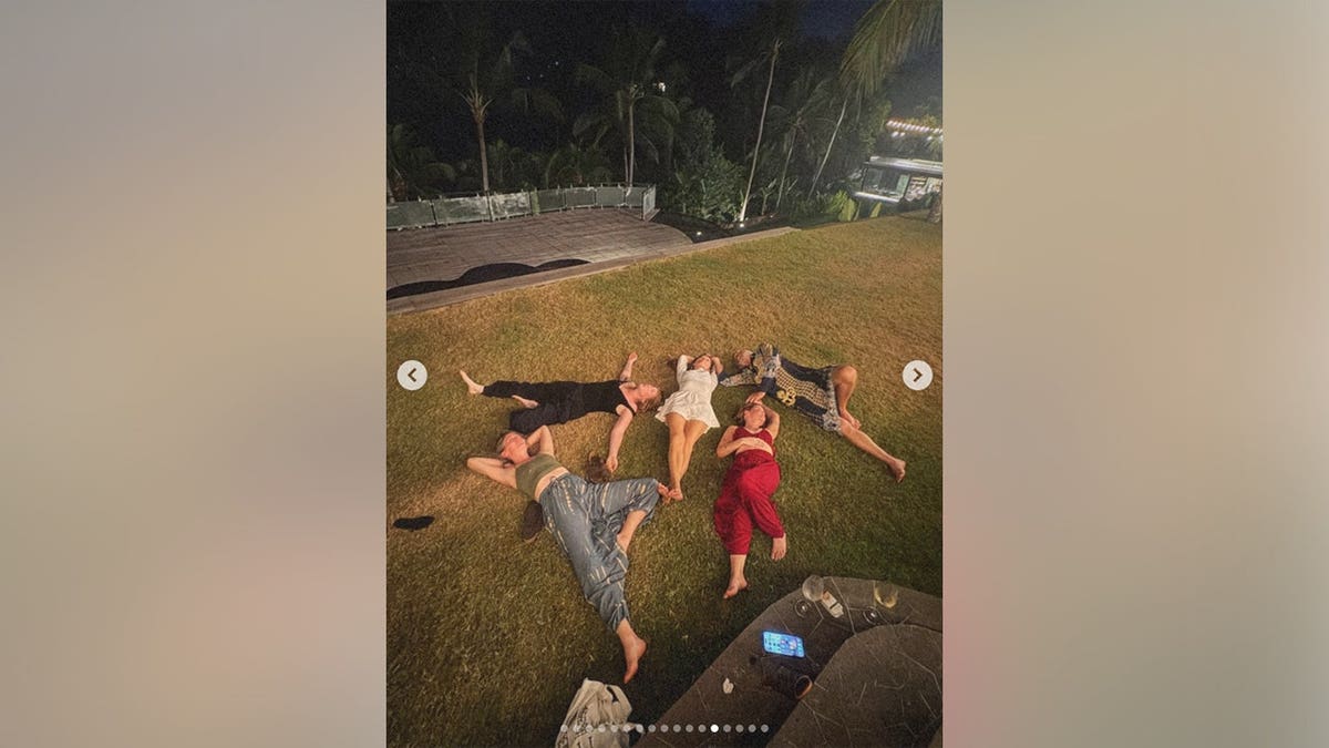Maren Morris laying on the grass with her friends.