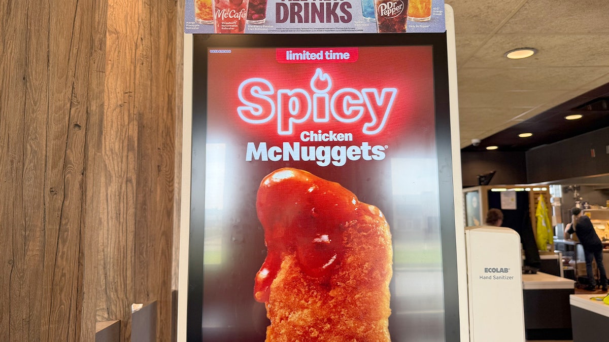 A display sign inside a McDonald's reads, "Limited time Spicy Chicken McNuggets."