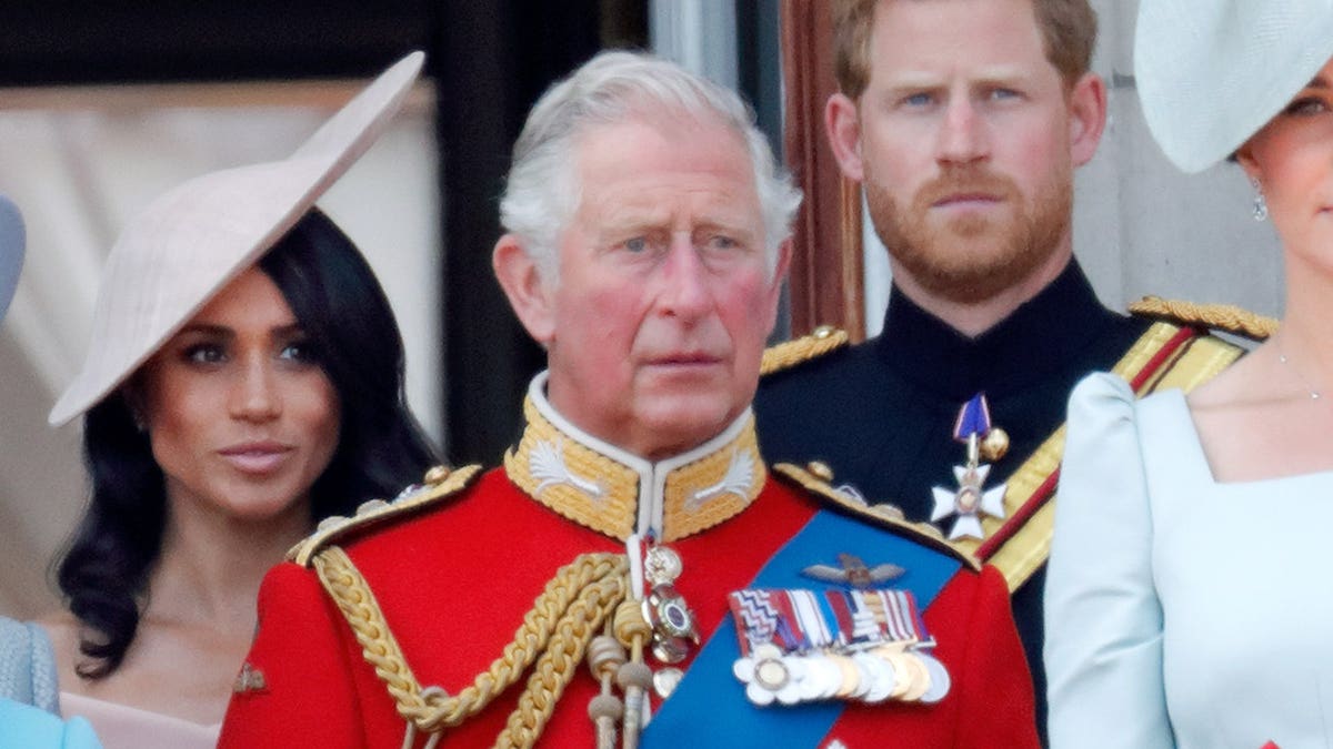 Meghan, Duchess of Sussex, Prince Charles, Prince of Wales and Prince Harry stand on Buckingham Palace balcony.