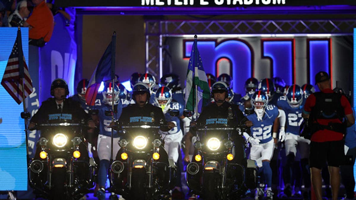 NYPD members lead the New York Giants onto the field at MetLife Stadium.