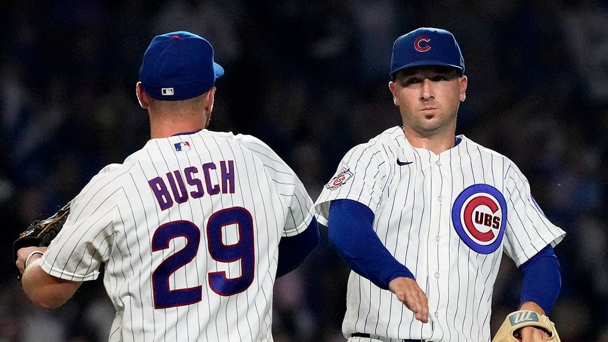 Michael Busch and Alex Bregman celebrate after the Cubs defeated the Brewers.