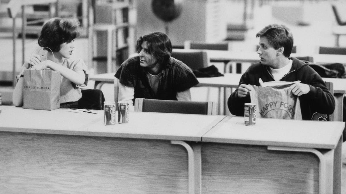Molly Ringwald, Judd Nelson and Emilio Estevez stand on the set of The Breakfast Club.