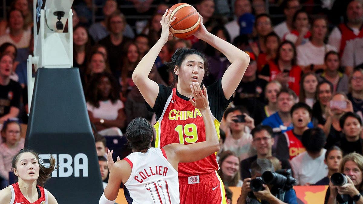 Napheesa Collier and Ziyu Zhang battle for the ball during a women's basketball game.