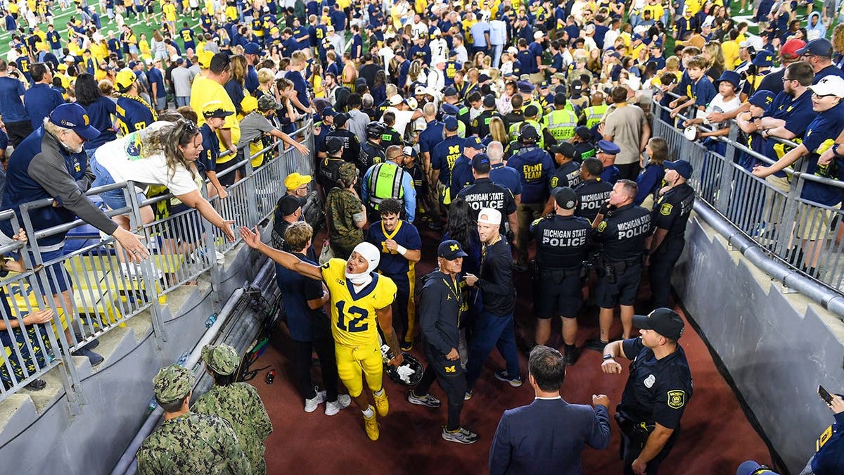 Nathaniel Owusu-Boateng of Michigan walks off the field after winning a college football game.
