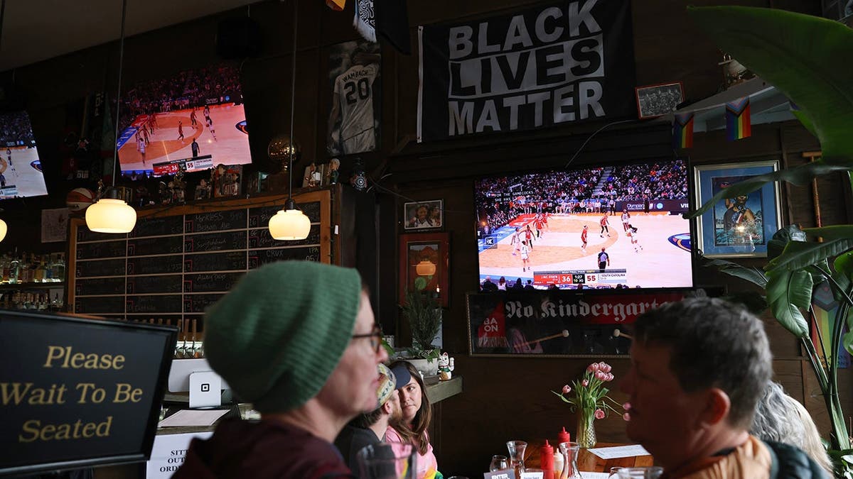Patrons watch a basketball game on screens at The Sports Bra in Portland, Oregon.