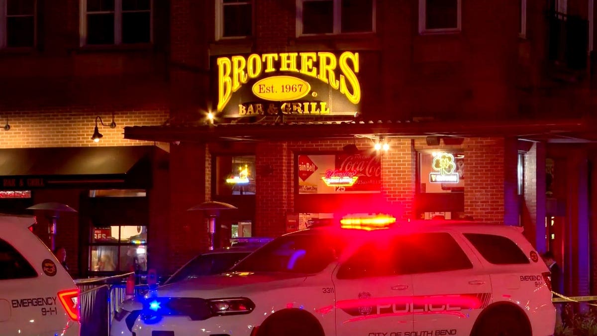 police cars secure a scene of a shooting at Eddy Street Commons in South Bend, Indiana