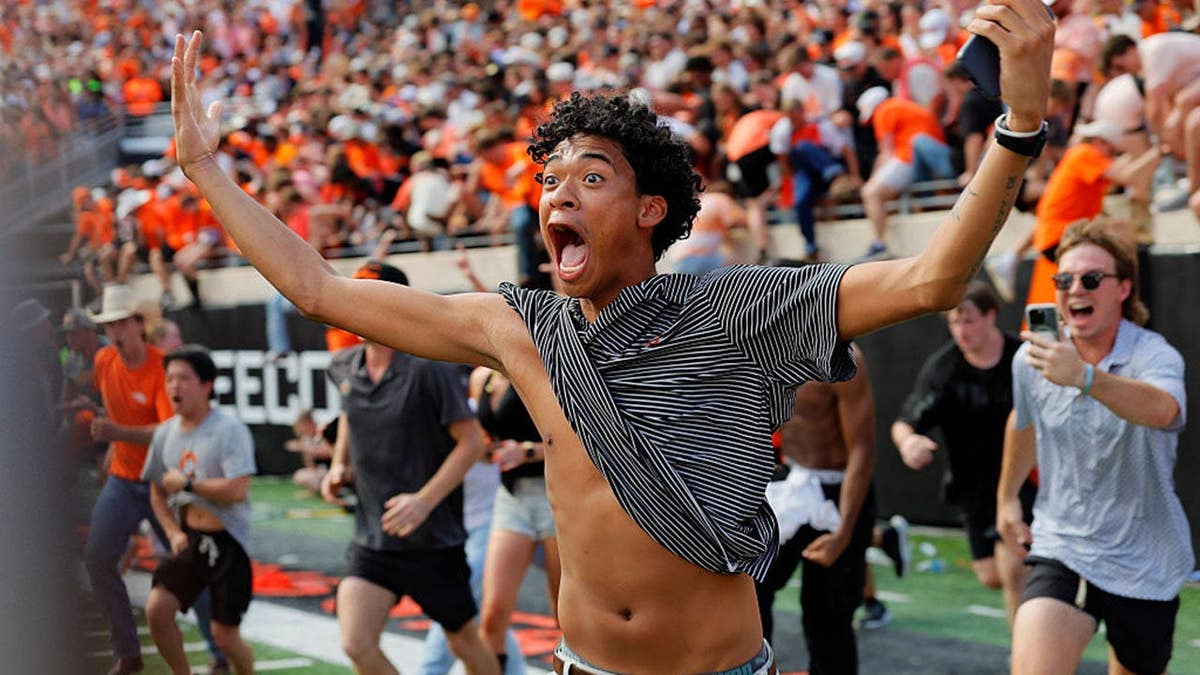 Oklahoma State fan runs onto the field at Boone Pickens Stadium after the Cowboys beat Oregon.