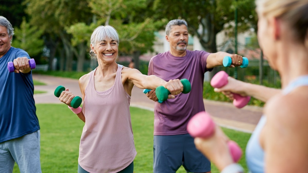 Older adults lifting weights outdoors