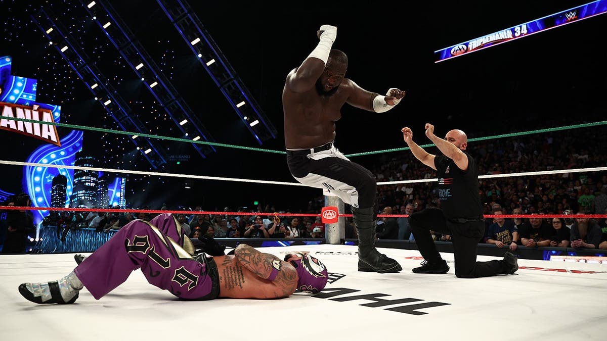 Omos elbow drops Rey Mysterio in the ring at MGM Grand Garden Arena.