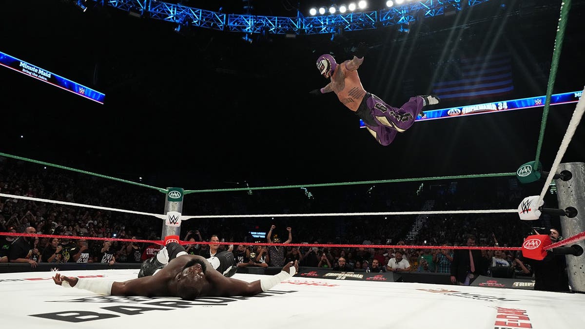 Omos and Rey Mysterio wrestle in the ring at MGM Grand Garden Arena.