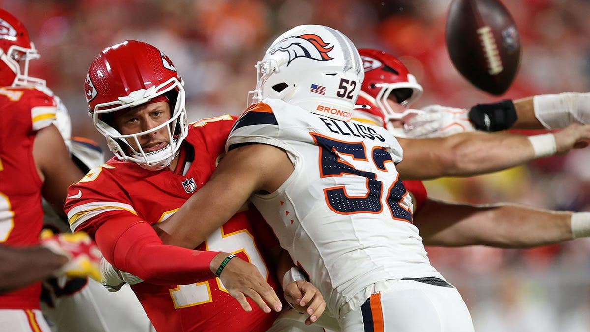 Patrick Mahomes throws a pass against Jonah Elliss during an NFL game at Arrowhead Stadium.