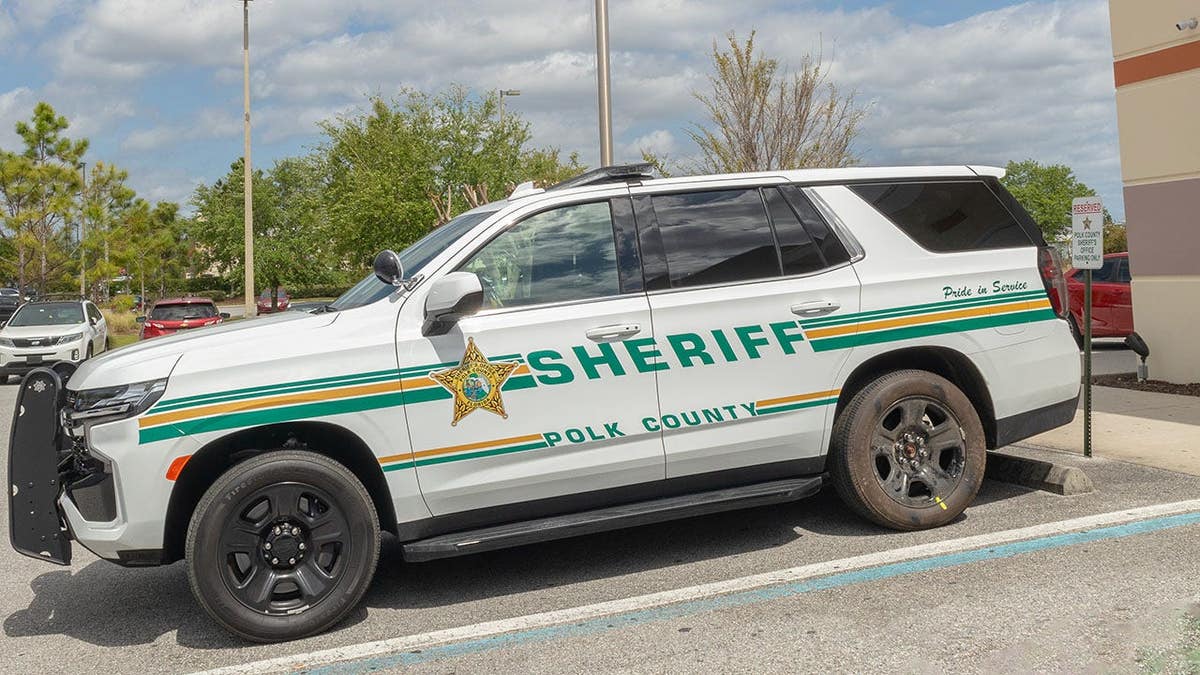 Polk County Sheriff SUV parked in a lot with American flag visible in background.
