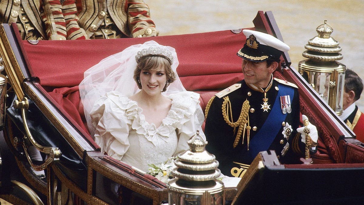 Prince Charles and Diana ride in an open carriage following their wedding in London.