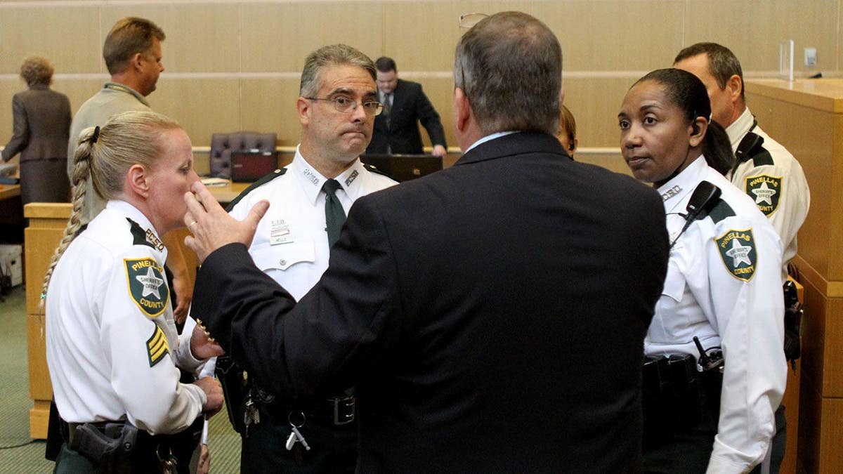 Rob Bains meets with sheriff deputies in a courtroom in Clearwater, Florida.