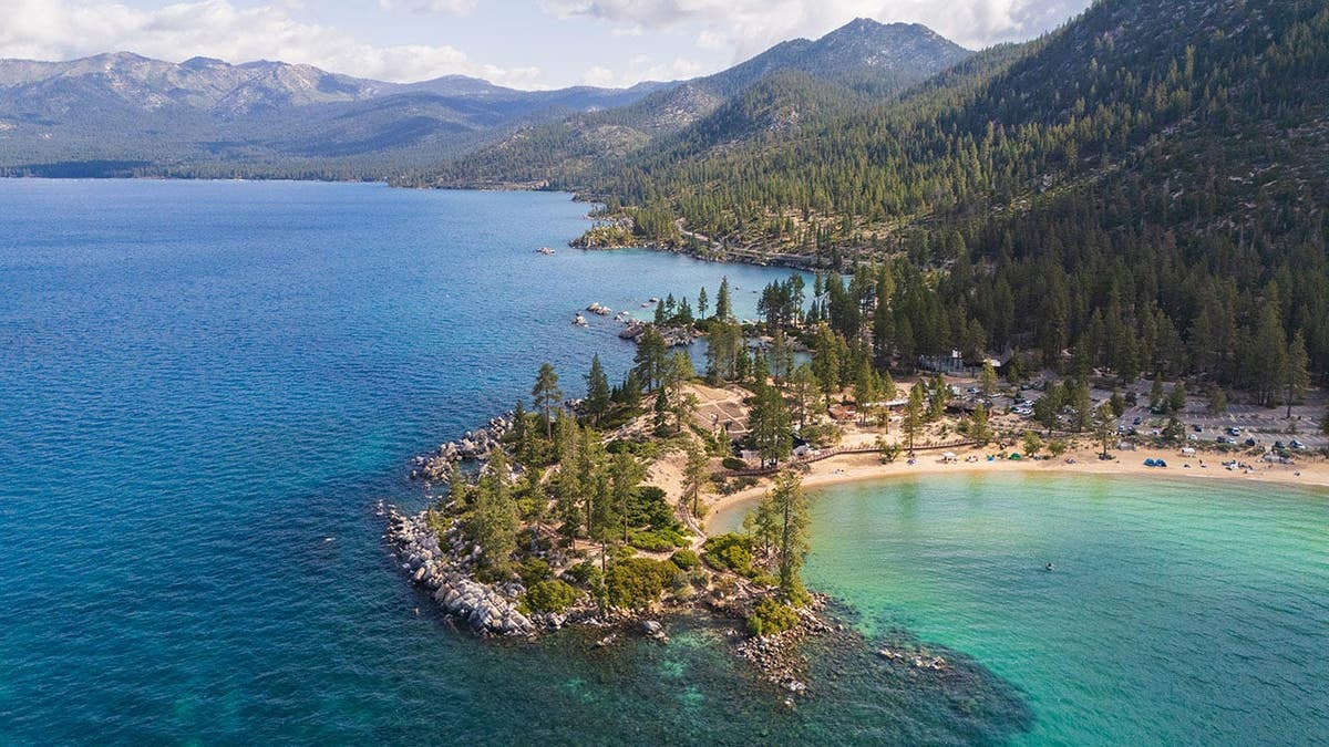 Turquoise lake water swirls around smooth gray rocks at Sand Harbour Beach, Lake Tahoe.