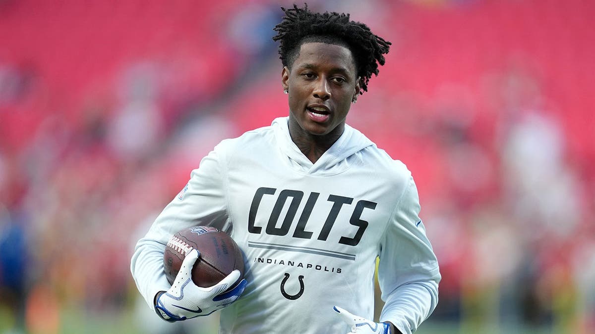 Sauce Gardner, wearing Colts uniform number 1, warms up on the field before the game.