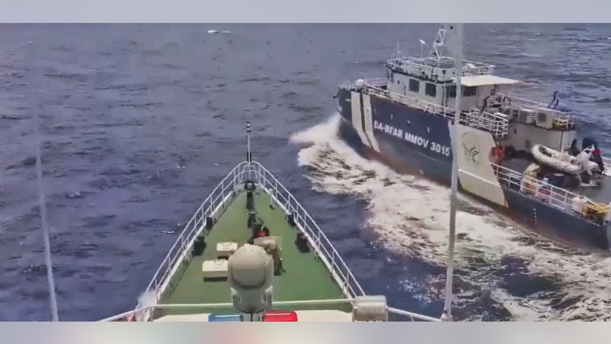 View from the bow of a ship directly approaching a Philippine Bureau of Fisheries and Aquatic Resources vessel, marked DA-BFAR MMOV 3015, as it crosses close by in open water