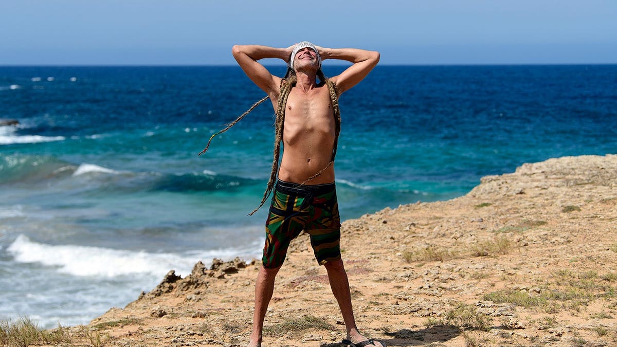 Stephen Lashbrook looking triumphant in front of ocean.