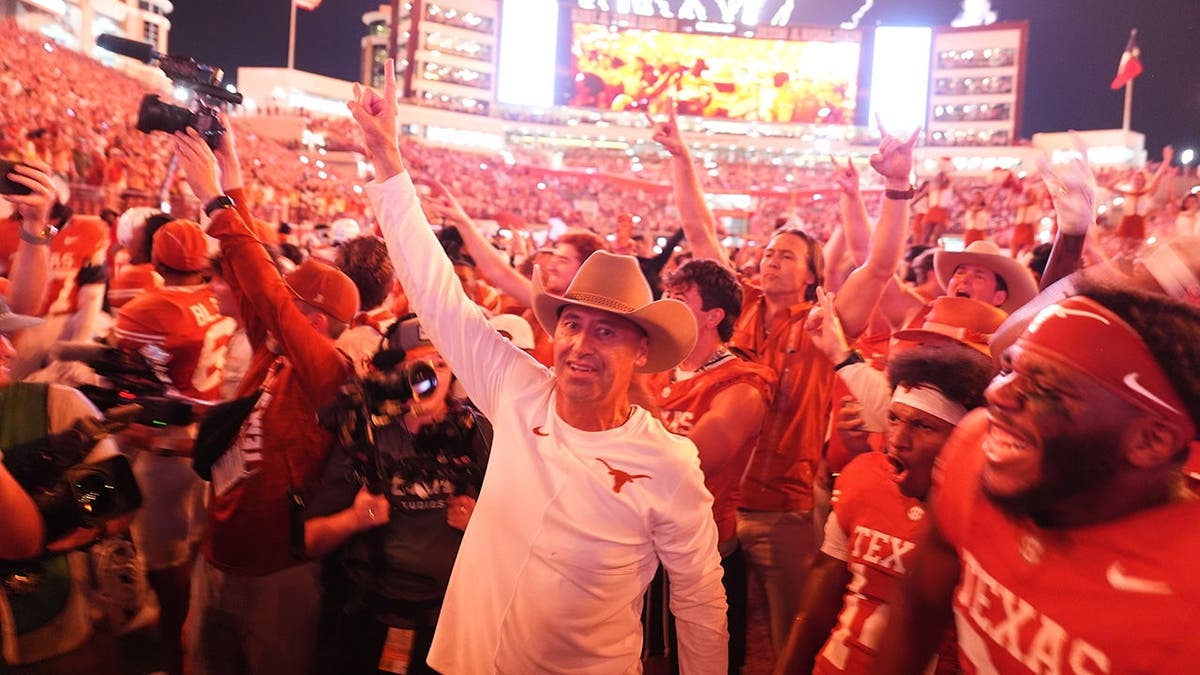 Steve Sarkisian celebrates with Texas players after a win over Ohio State.