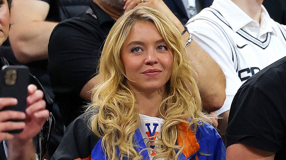 Sydney Sweeney and Scooter Braun seated during Game Five of the 2026 NBA Finals.
