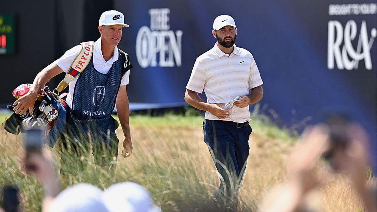 Scottie Scheffler of the United States walks with his caddie Ted Scott