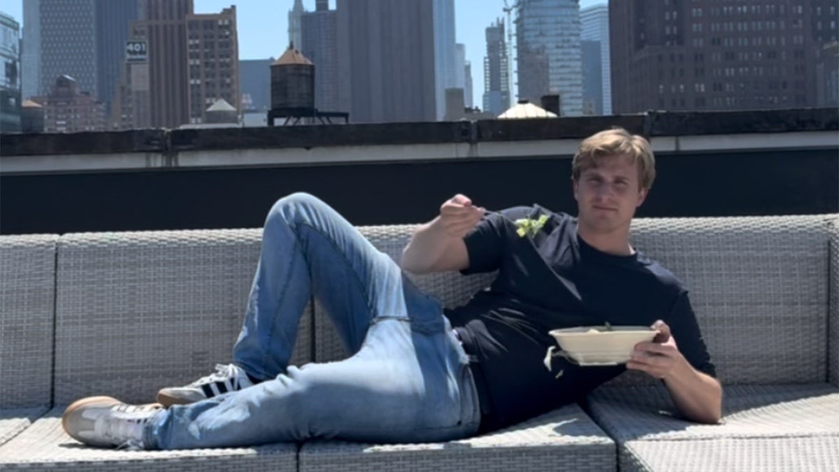 Tim Donohue stretches out while holding a fork with salad from a Sweetgreen bowl.