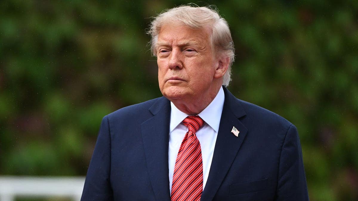 President Donald Trump stands outside the main building entrance of Aras an Uachtarain in Dublin, Ireland.