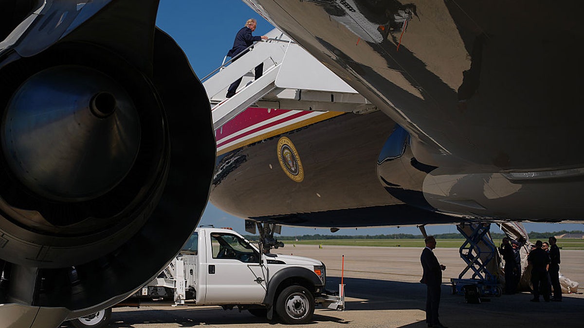 President Donald Trump boards Air Force One as crew members work on an escape device that inflated off the side of the Qatari-gifted "Bridge" aircraft, on Sept. 9, 2026, at Joint Base Andrews in Maryland.