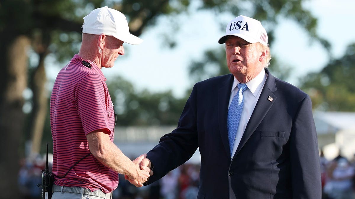 Donald Trump and Brandt Snedeker stand for the trophy ceremony at Medinah Country Club.