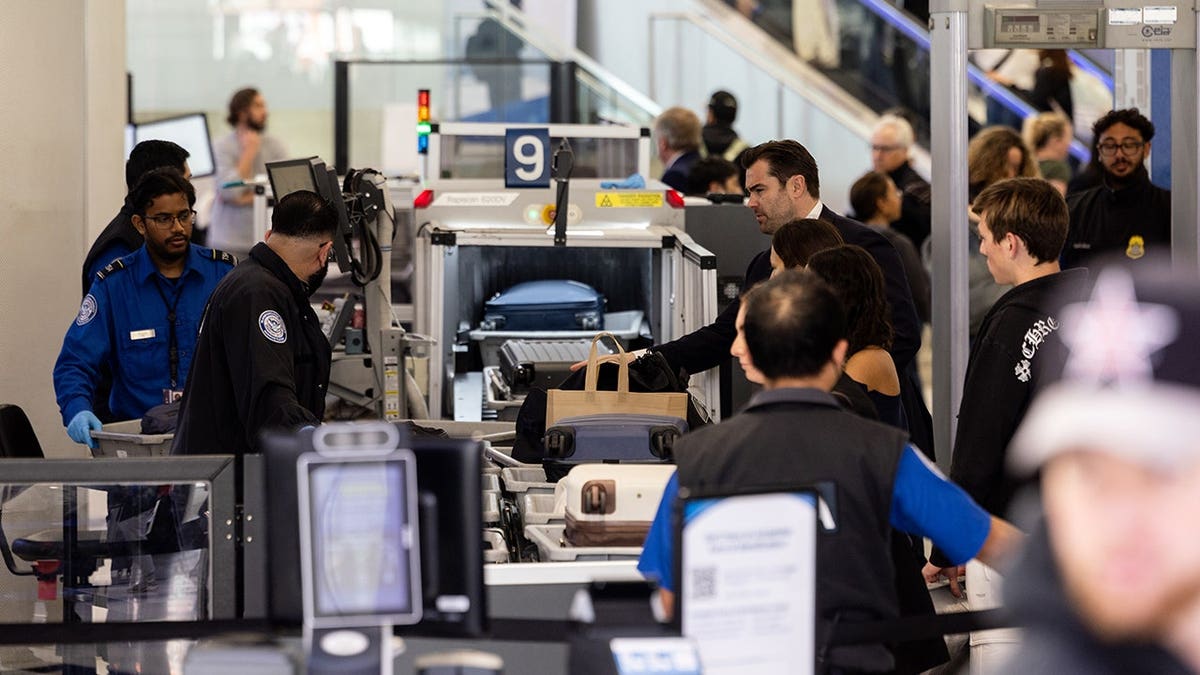 TSA officers screen passengers and check luggage at a security checkpoint in Terminal 7 of Los Angeles International Airport.