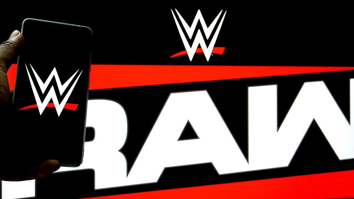 WWE logo displayed on a smartphone with WWE Raw logo in the background