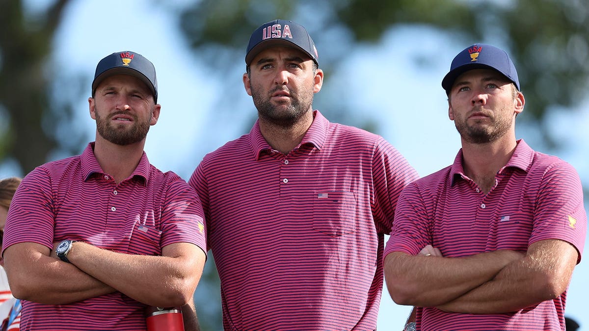 Wyndham Clark, Scottie Scheffler and Sam Burns watch the action on the 15th green during the Presidents Cup at Medinah Country Club.