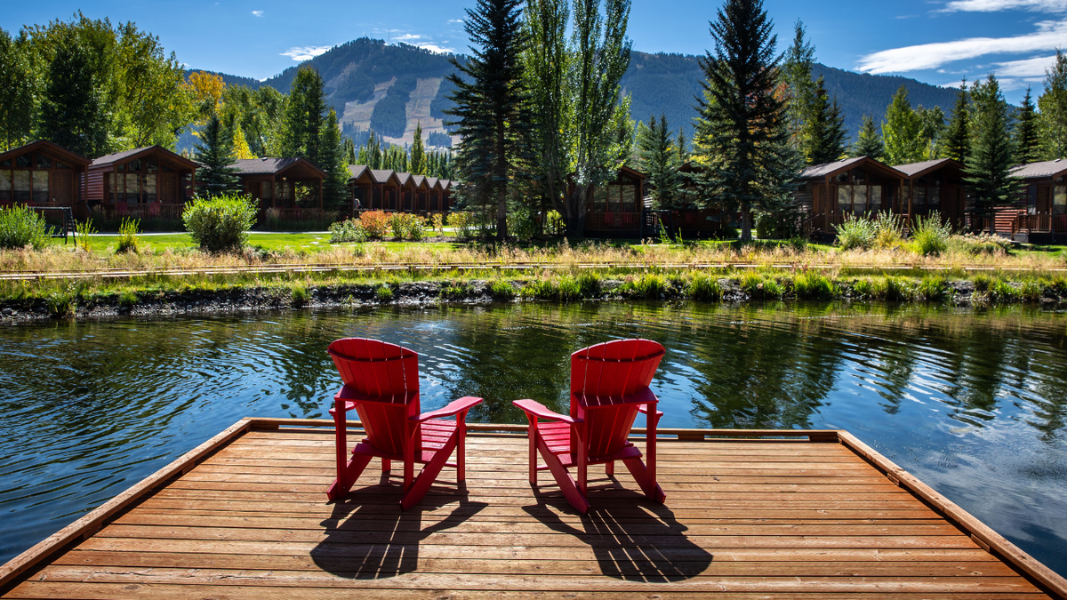 Adirondack chairs are situated along Flat Creek at the Rustic Inn near downtown Jackson and across the street from the National Elk Preserve.