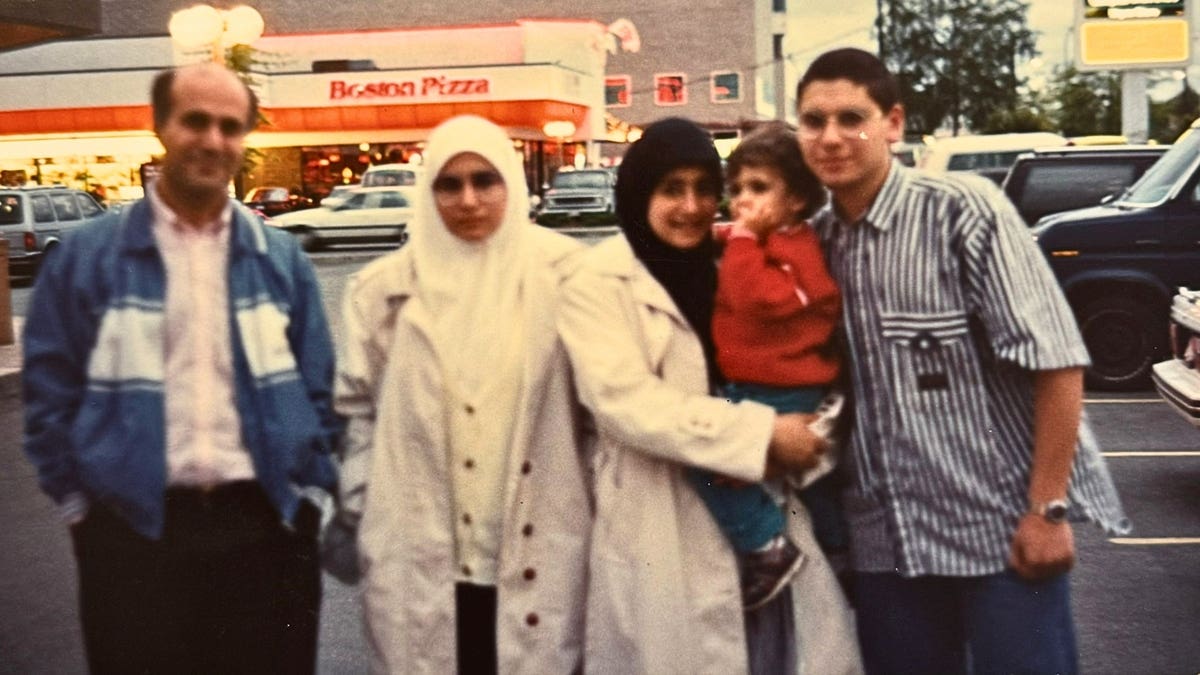 Muslim family poses for photo on street sidewalk in the 90s