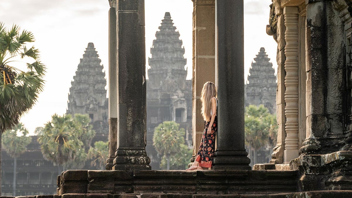 Young woman explores Angkor Wat temple in Cambodia.