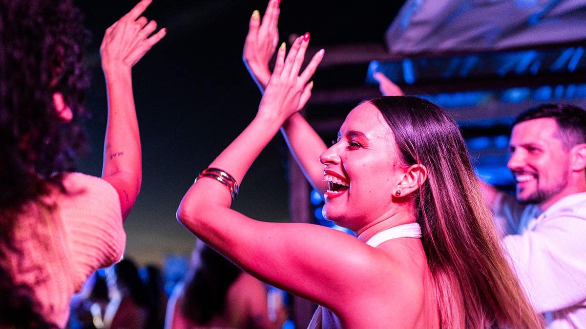 Young woman dancing with friends at a music festival.