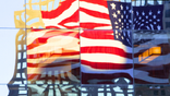 The American flag is reflected on a corporate building in New York City.